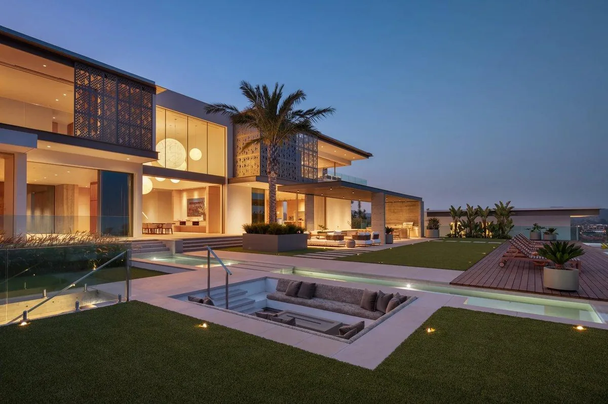 A completed modern residence with pool and terrace at dusk